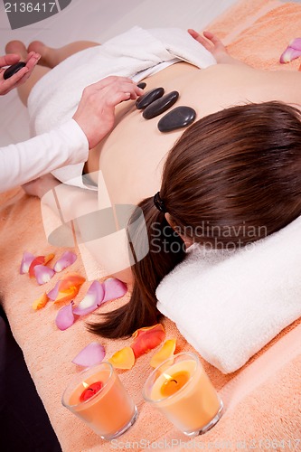 Image of young attractive woman get hot stone massage 