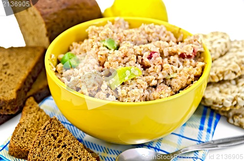 Image of Porridge rye flakes with bread and quince on a napkin