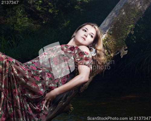 Image of Beautiful girl in floral dress stand in garden.