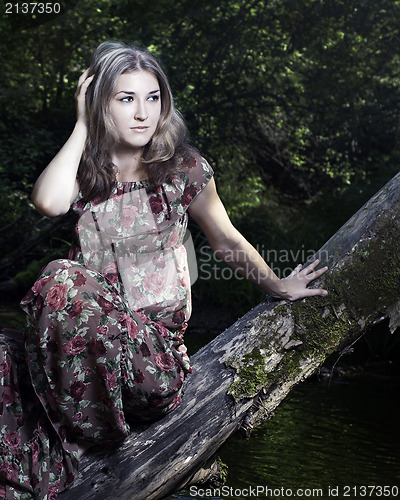 Image of Beautiful girl in floral dress stand in garden.