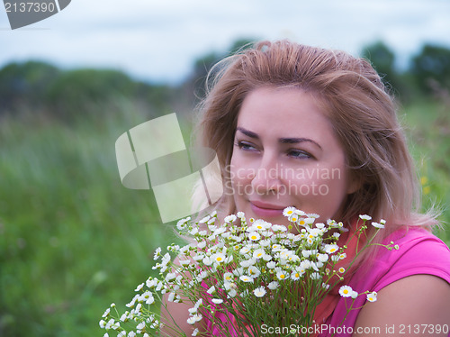 Image of Portrait of young woman with bouquet of daisies.