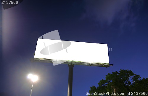 Image of Blank billboard in a blue sky and green tree as a background