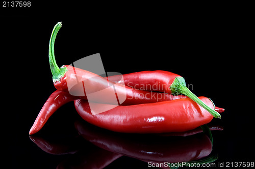 Image of chili peppers with reflection on black