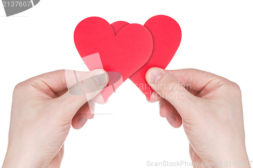 Image of Hands holding two red paper  hearts 