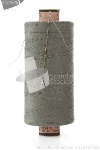 Image of grey bobbin thread with a needle