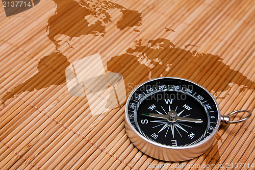 Image of black compass on the abstract world map
