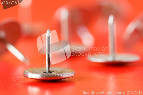 Image of drawing pins on red background