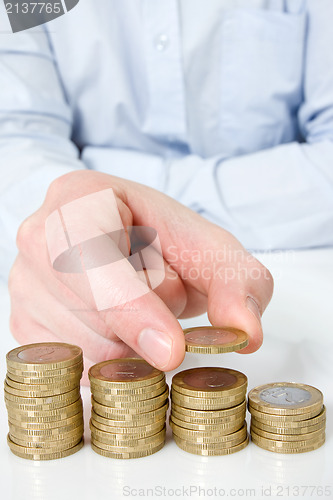 Image of  hand putting coin to money staircase