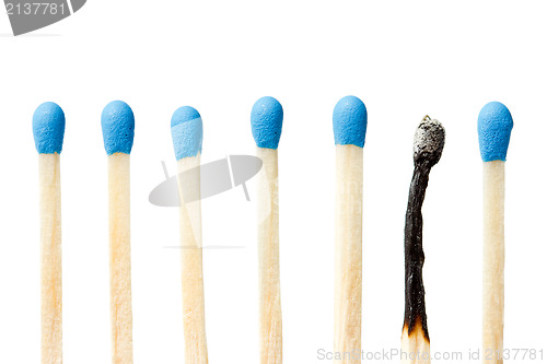 Image of  burnt match and a whole blue matches