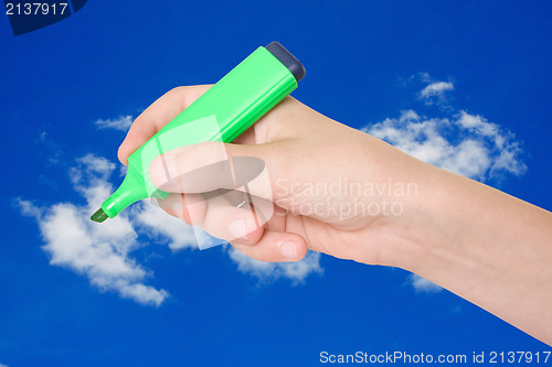 Image of hand with a marker on sky background