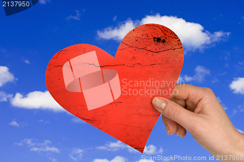 Image of hand with heart on sky background