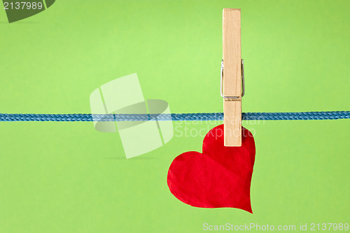 Image of  red heart hung  over a green background