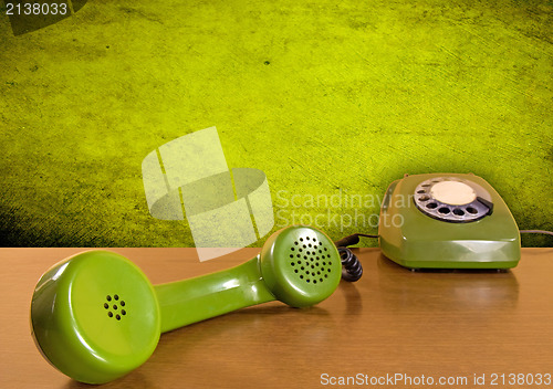 Image of green telephone on the wooden table