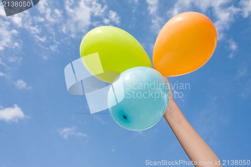 Image of hand with color balloons