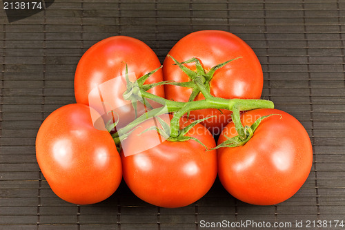 Image of tomatoes on black tablemat