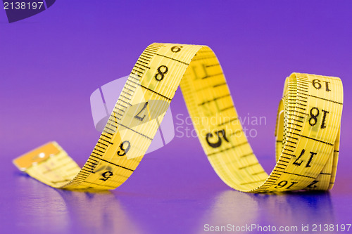 Image of yellow measure tape on purple