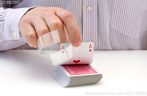 Image of hand lifting up playing card