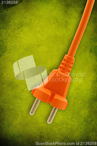 Image of orange electrical plug on  green background