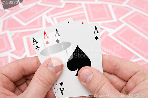 Image of hands with three aces