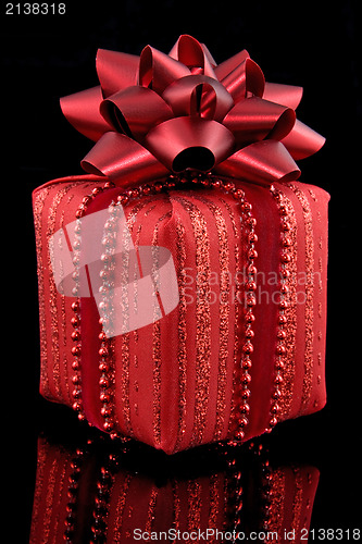 Image of red gift on black background 