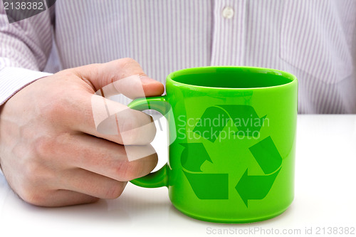 Image of hand hold a  cup with recycled symbol