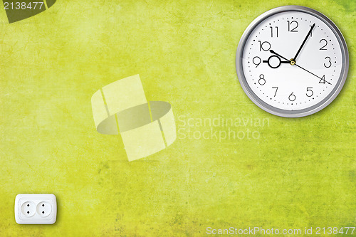 Image of green wall with clock and electric socket