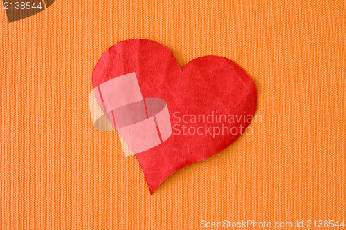 Image of paper heart on the orange background