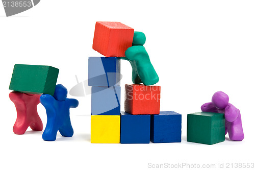 Image of  plasticine people building wooden blocks