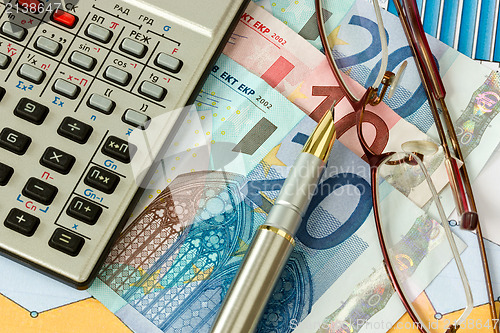 Image of European money, pen, calculator and glasses