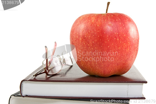Image of red apple and glasses on the books