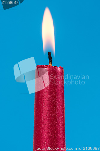 Image of Burning candle over a blue background