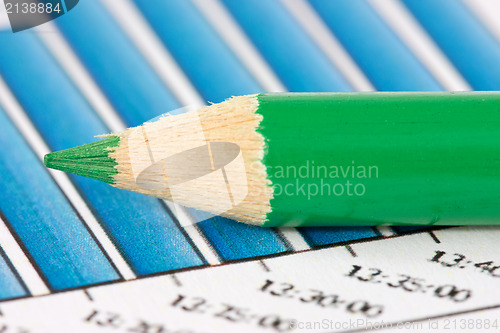 Image of green pencil on financial graphs