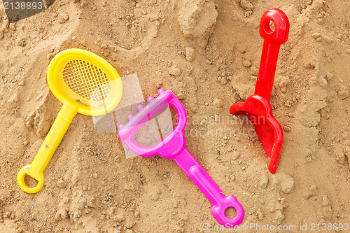 Image of color plastic toys on a sand