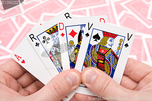 Image of hands holding four playing cards