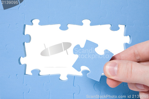 Image of Hand collecting  blue puzzle 