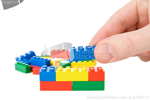 Image of hand build a color plastic  bricks