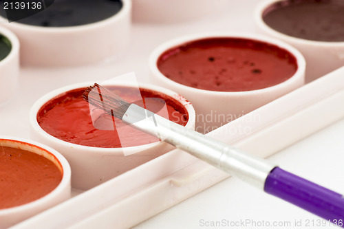 Image of paintbrush on watercolor paint tray