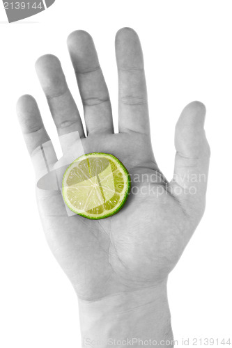 Image of human hand with a green lemon