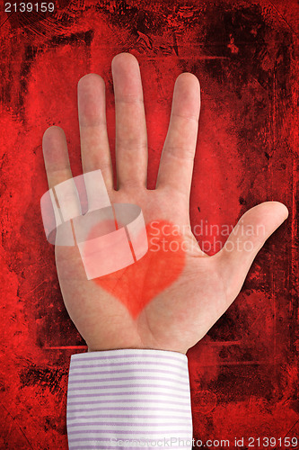 Image of hand with heart shape on dark red background