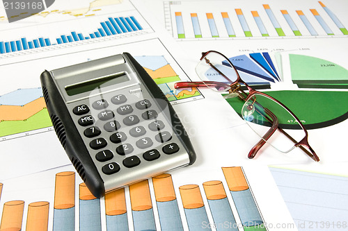 Image of colorful  charts, calculator and glasses