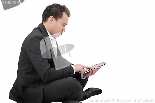 Image of Young man sitting on a floor and using tablet pc 