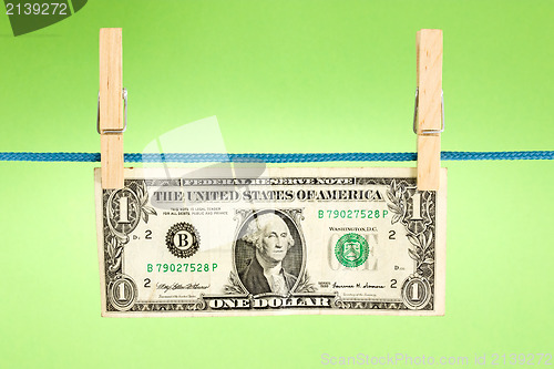 Image of dollar hung  over a green background