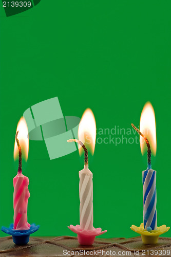 Image of candles in a cake, over a green background