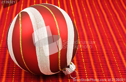 Image of christmas bauble on red decorative background