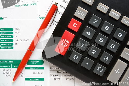 Image of calculator,pen and the financial reports