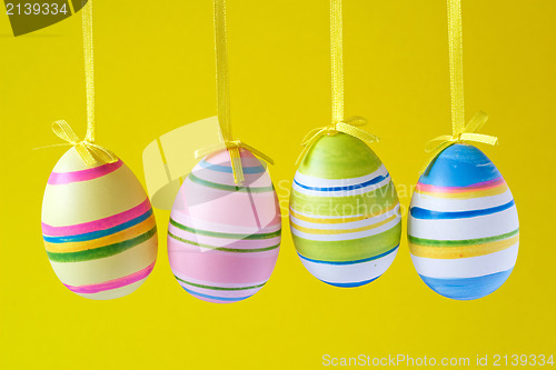 Image of easter eggs hung on yellow background