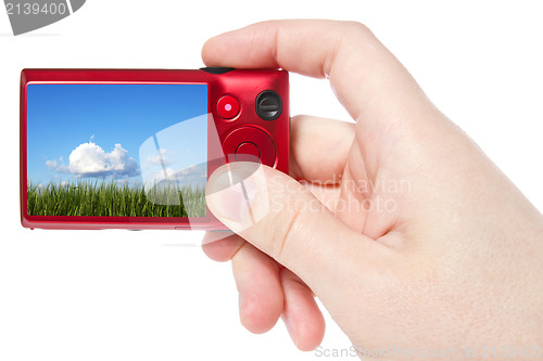 Image of hand hold camera with  picture of nature