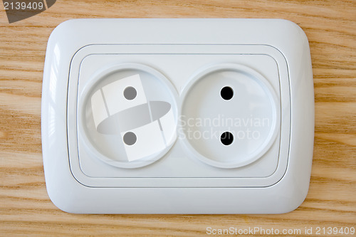 Image of white electric outlet on wooden wall