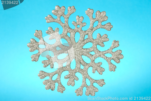 Image of snowflake isolated on blue background