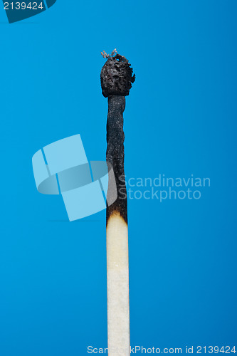 Image of burnt match stick isolated on blue